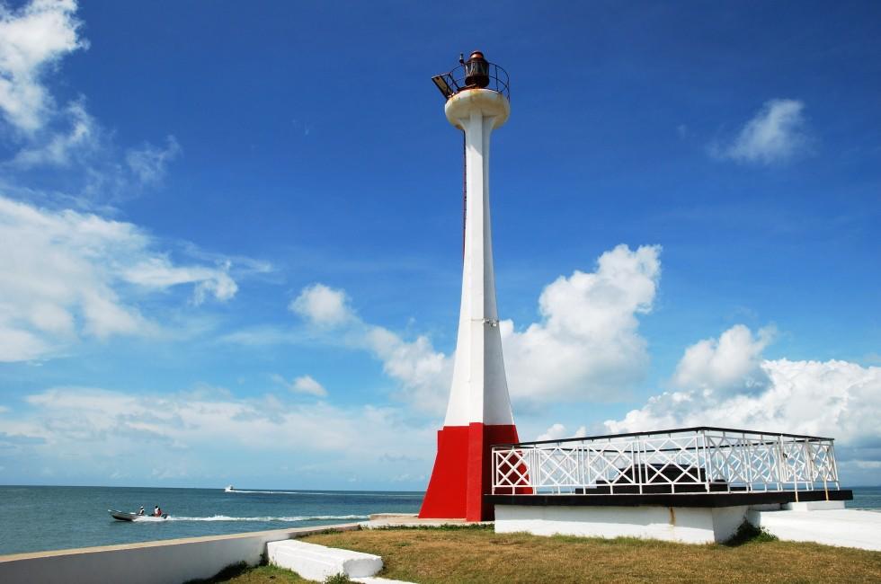 The lighthouse with boats passing by in Belize City (Belize).