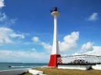 The lighthouse with boats passing by in Belize City (Belize).