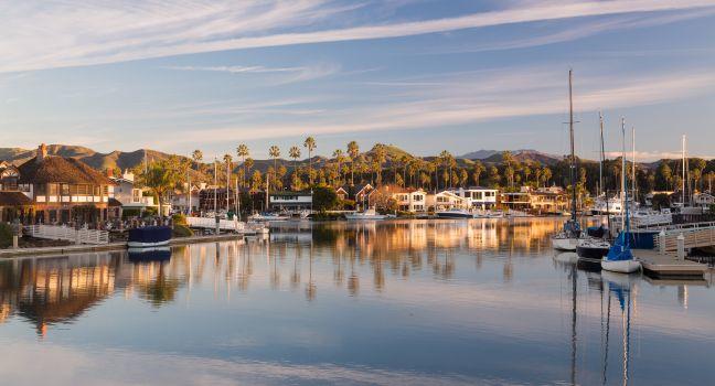 Sunrise at residential development by water in Ventura California with modern homes and yachts boats