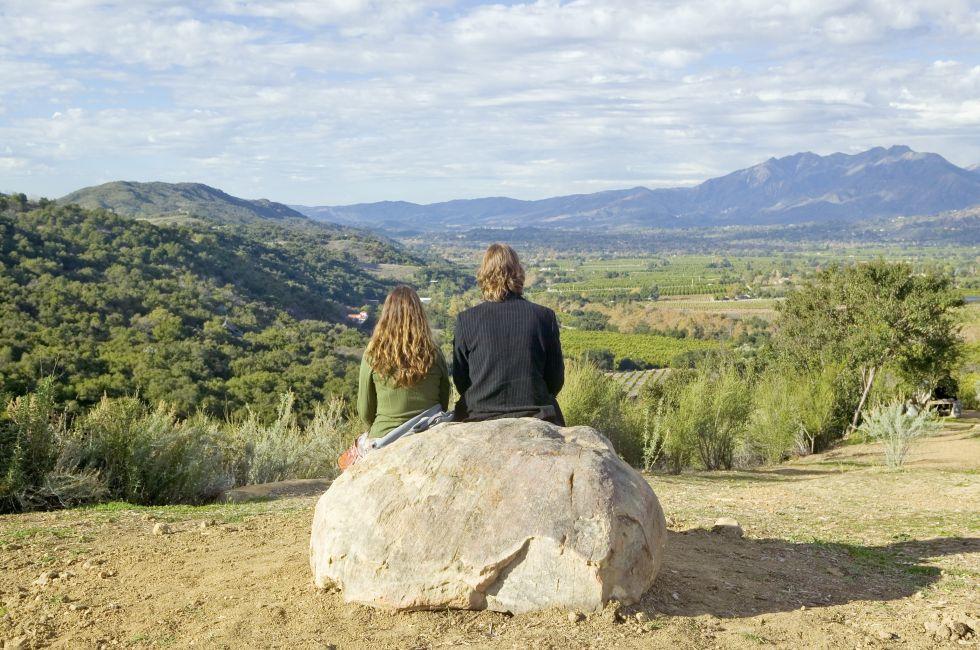 Couple sits and meditates at Meditation Mount's Point overlooking the Ojai Valley, CA