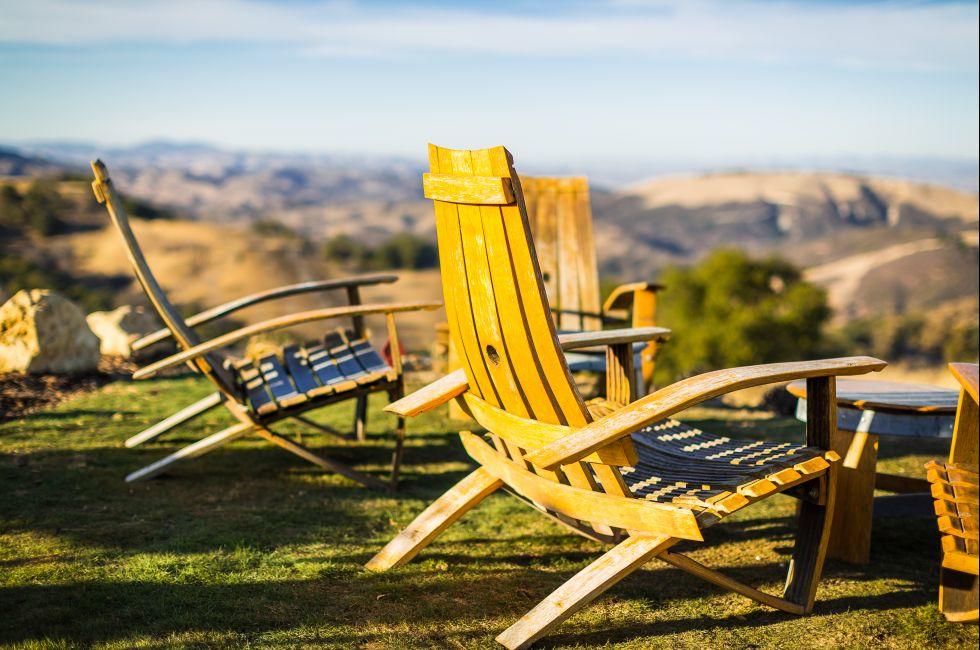 Color shot of adirondack chairs on green grass overlooking Paso Robles wine country at a winery in California