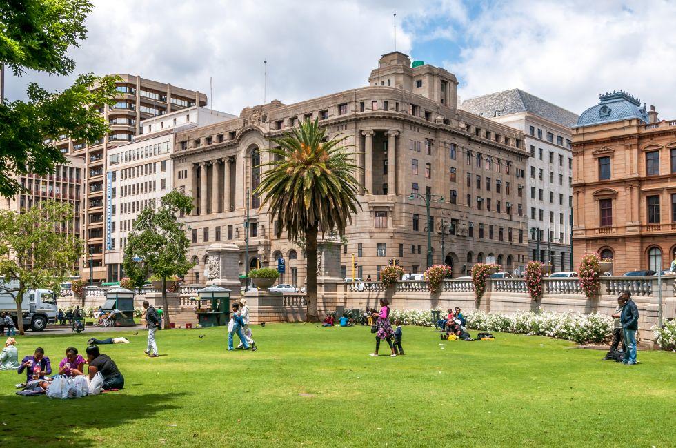 PRETORIA, SOUTH AFRICA - OCTOBER 13, 2012 - Church Square in The Pretoria. People during the day resting on the grass in the center of the square.