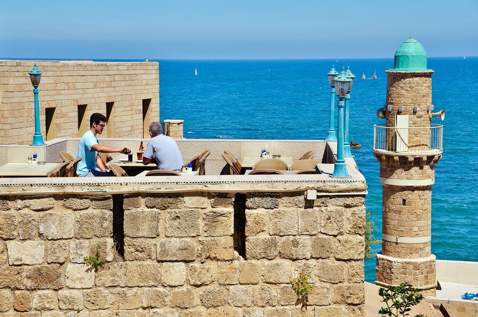 JAFFA, ISRAEL - APR 11, 2014: People eating breakfast with views of the Mediterranean in Jaffa, Tel Aviv, Israel