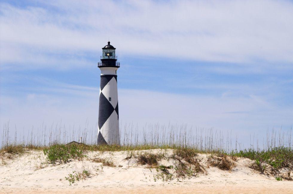 A historic lighthouse guiding ships away from rocky shoals.