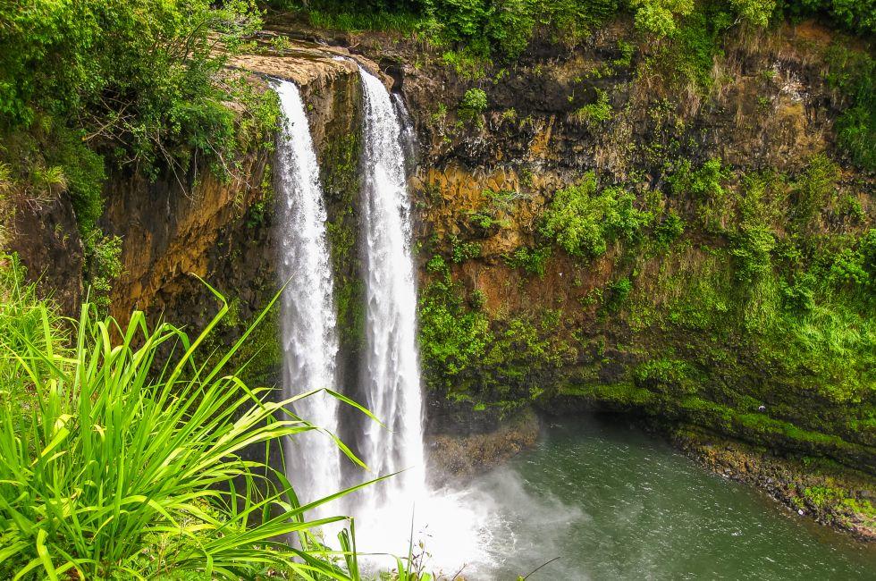 Aerial view of tropical Manawaiopuna Falls also called Jurassic Park Falls in Kauai, Hawaii, USA. .