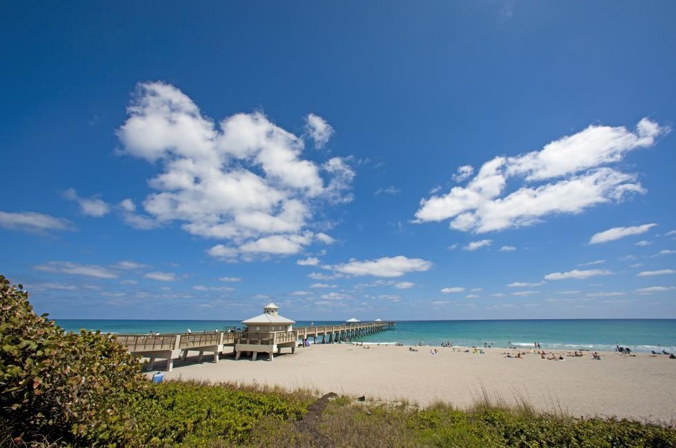 A dock goes far out into the water in Palm Beach, Florida.;