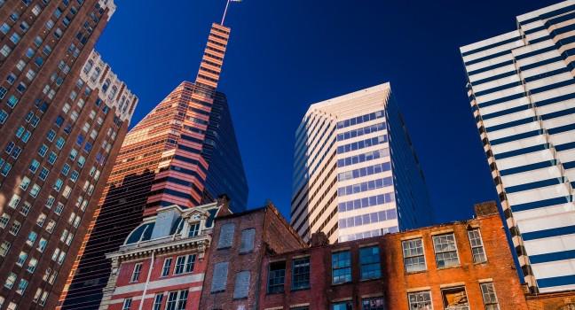 Looking up at a mix of modern and old buildings in Baltimore, Maryland.