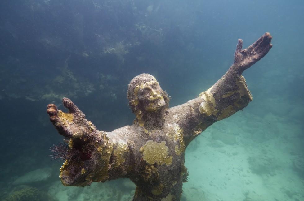 Christ of the abyss - religious underwater statue encrusted in corals, placed about 25 feet deep in John Pennekamp Coral Reef State Park in Florida Keys. Replica of the Italian sculpture. Wide angle, side flash and sunlight combined.