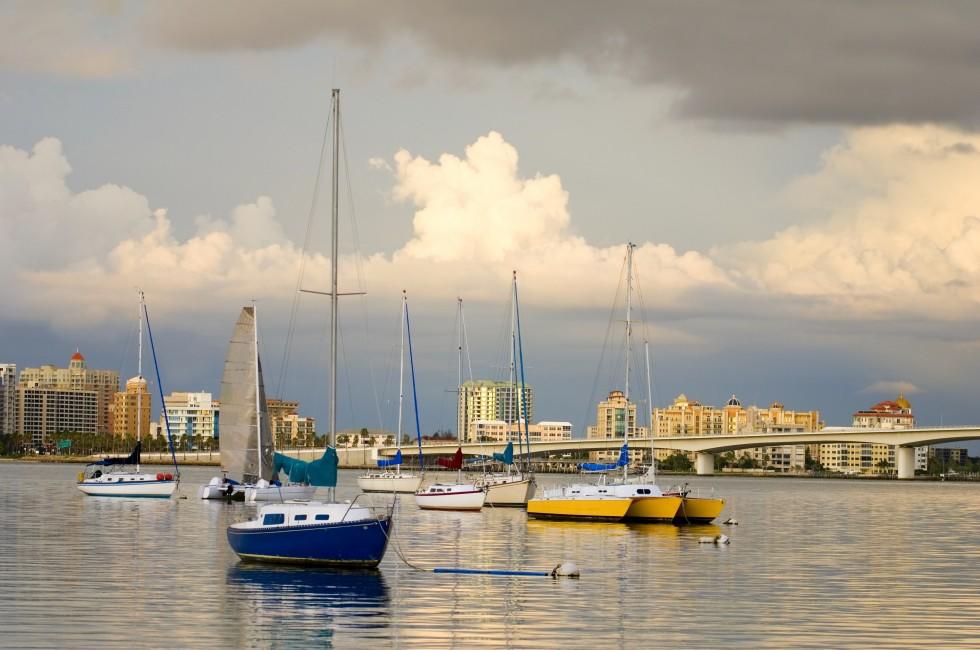 Boats anchored in a harbor under cloudy skies; 