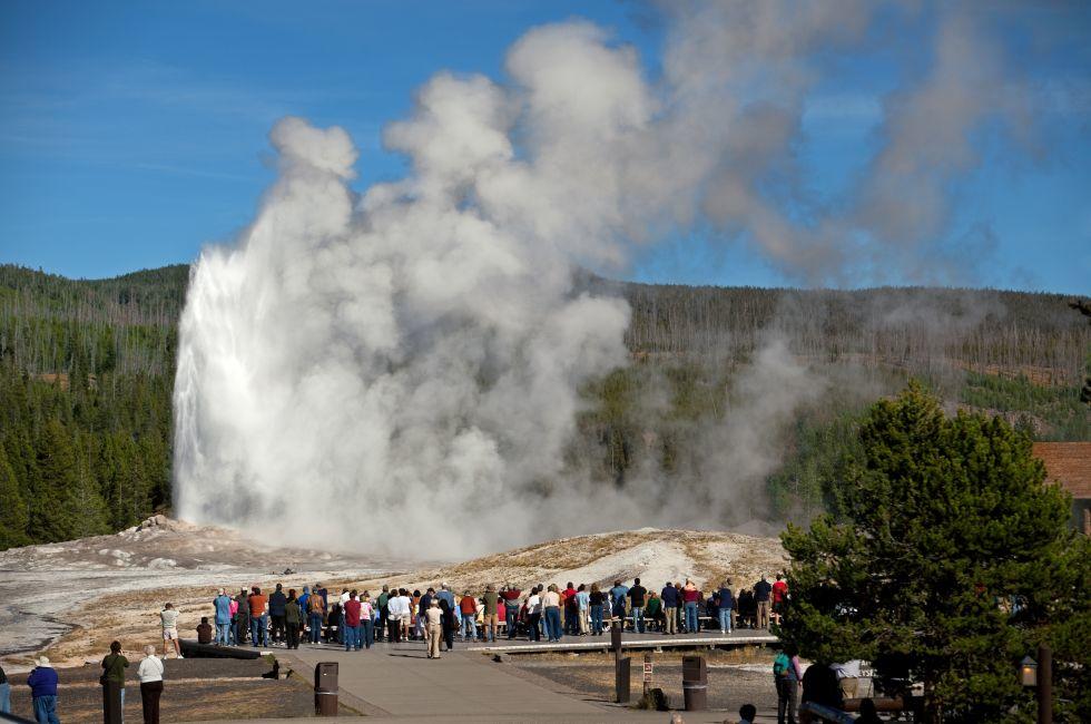 Tourists watching the Old Faithful erupting in Yellowstone National Park.