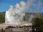Tourists watching the Old Faithful erupting in Yellowstone National Park.