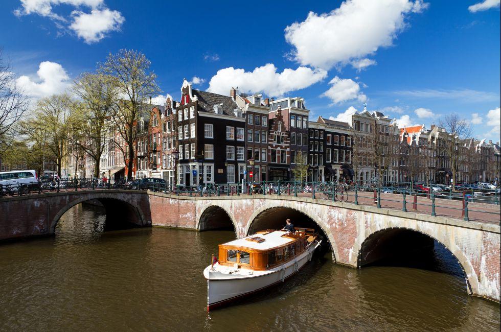 Amsterdam canal intersection with white boat.