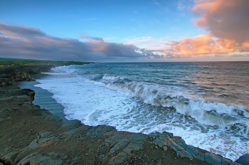 Views of the sea and black lava rocks of recent eruptions of Kilauea from Kalapana for sunset, Puna district, Big island, Hawaii.