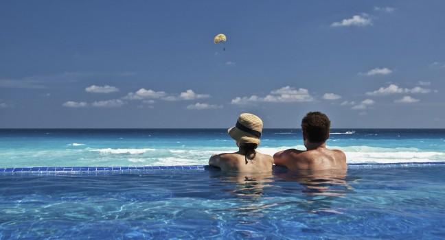 couple enjoying the view of the Caribbean from an infinity pool.
