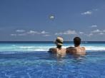 couple enjoying the view of the Caribbean from an infinity pool.