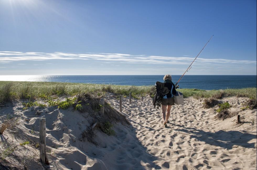 CAPE COD, MA - JUNE 19: A woman goes fishing at Race Point Beach on June 19, 2010 in Cape Cod. Cape Cod was the historic landing of Mayflower and is today a major travel destination in Massachusetts.