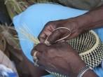 Hands weaving sweetgrass into beautiful baskets.