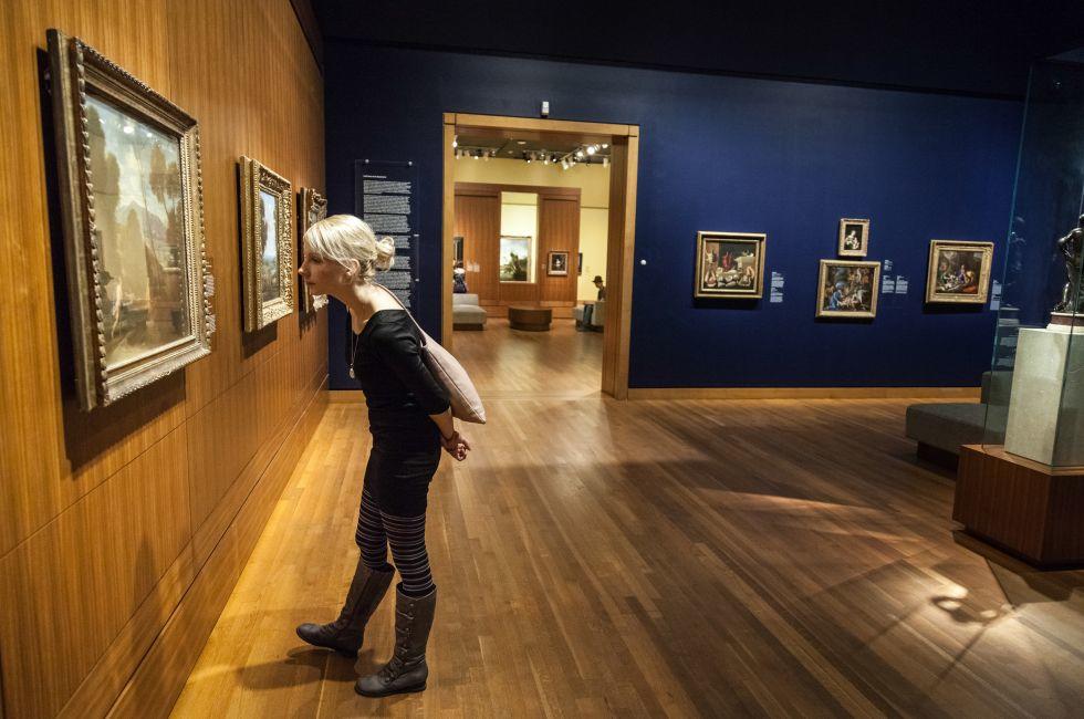 Montreal, Canada, Feb 22 2014 - Montreal Fine Arts Museum Room with Paintings on the wall and Young Adult looking at it.