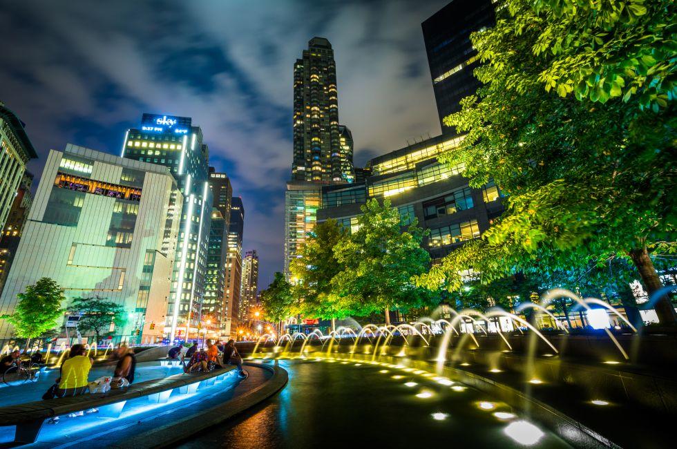 Fountains and buildings at night at Columbus Circle, in Manhattan, New York.