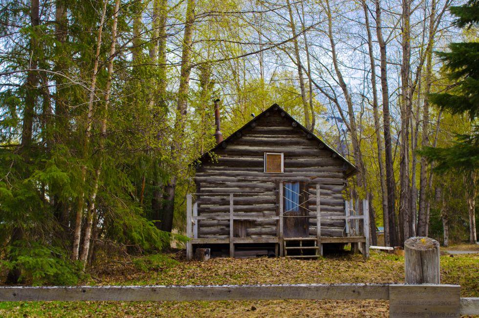 Old cabin in front of mountain in Hope Alaska an old mining town with a front porch.