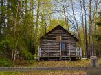 Old cabin in front of mountain in Hope Alaska an old mining town with a front porch.