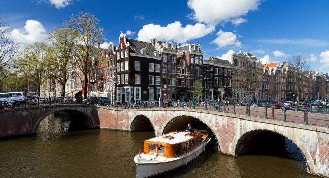 Amsterdam canal intersection with white boat.