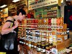 Woman shopping for delicious homemade preserves sold by an Amish family at the Reading Terminal Market in Philadelphia, Pennsylvania.