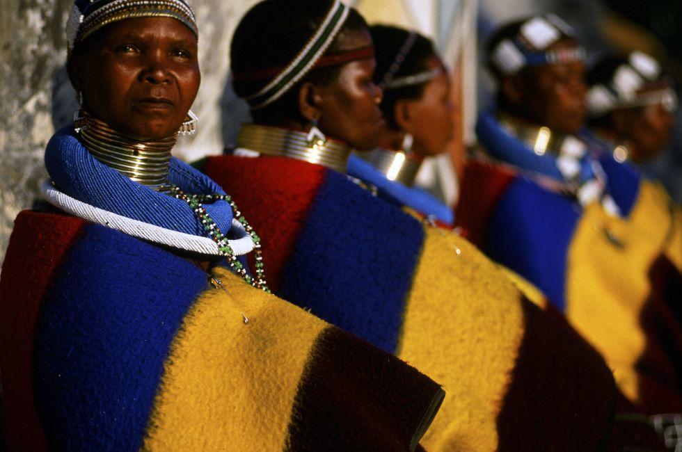 Neck-stretching brass coils announce marrigage as do a beaded jocolo wedding apron that mirrors the primary colors of the decorations hand painted by the mguni-speaking Ndebele.
