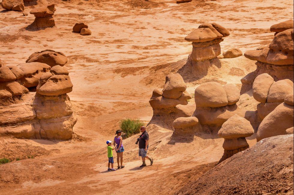 GREEN RIVER, UT, USA-JULY 2, 2013  Family Walks Among Goblins Mushroom Shaped Hoodoos Goblin Valley State Park Rock Canyon San Rafael Desert. Thousands of sandstone hoodoos like modern art statues.  