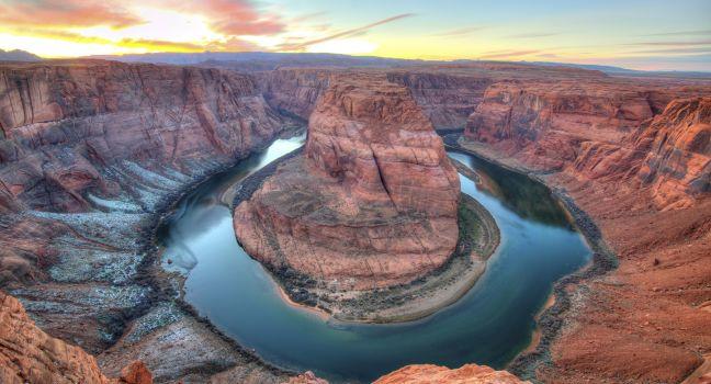 Winter sunset at Horseshoe Bend, Page, Arizona, United States. snow on the ground eroded red rock sandstone colorado river 180 degree turn headland.