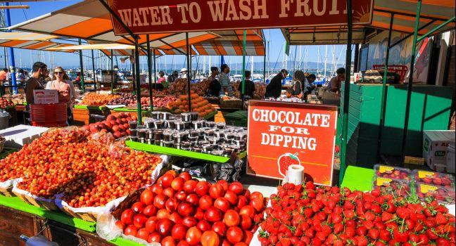 Summer crowds check out the fresh fruit and other items available at the Farmer's Market on Pier 39, located at the edge of famous Fisherman’s Wharf and the Embarcadero along San Francisco’s historic waterfront. Hugely popular, it is one of t