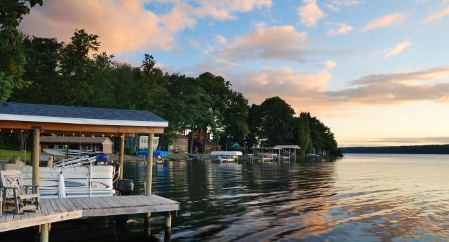 Lake house with pier and woods with sunrise in the morning in New York state Finger Lakes; 