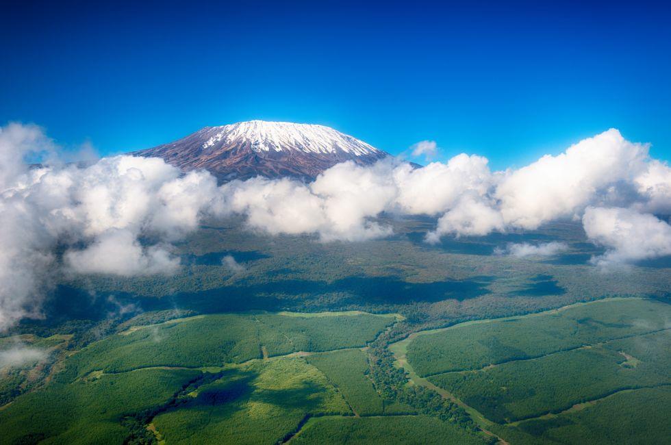 Aerial image of Mount Kilimanjaro, Africa's highest mountain, with snow and white puffy clouds from Kenya