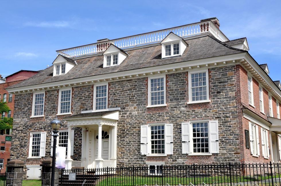 The field stone south front and wooden portico doorway of Georgian era Philipsburg Manor built in 1693 in Yonkers, New York.
