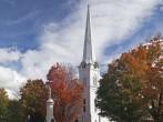 Autumnal shot of the main street of Manchester Vermont in fall as the bright trees turn orange and red.