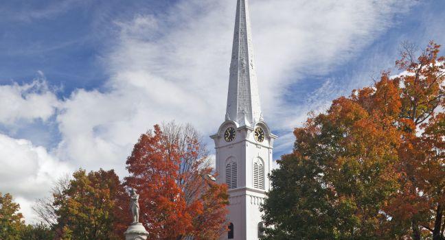 Autumnal shot of the main street of Manchester Vermont in fall as the bright trees turn orange and red.