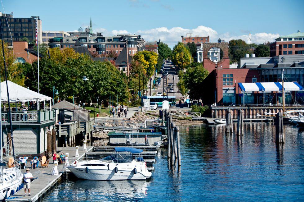 Burlington, VT, USA - September 30, 2013: People gather to watch the boats along the water at the Burlington Marina while pedestrians walk the Island Line Trail along the waterfront in the sun.