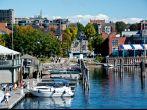 Burlington, VT, USA - September 30, 2013: People gather to watch the boats along the water at the Burlington Marina while pedestrians walk the Island Line Trail along the waterfront in the sun.