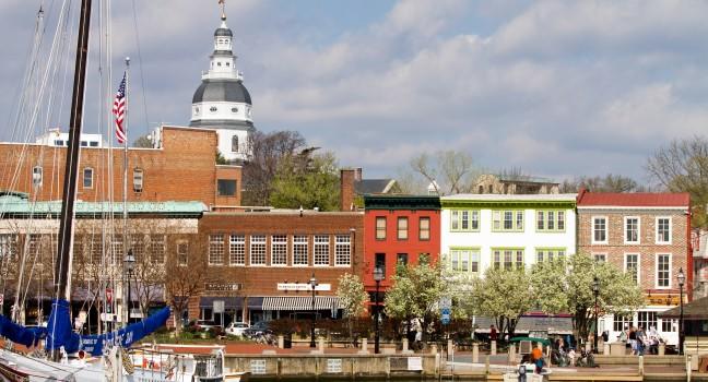 ANNAPOLIS, MARYLAND, USA - APRIL 12, 2013: Tourists shop along the waterfront in historic downtown Annapolis, Maryland, USA, the state capital, dome visible in the background, on April 12, 2013.