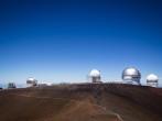 Observatory dome at the peak of Mauna Kea volcano, Hawaii. Telescope structure on volcano top above the main cloud layert.
