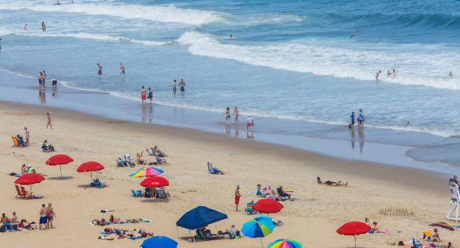 OCEAN CITY - JUNE 13: Tourists at the beach in Ocean City, MD on June 13, 2014. Ocean City, MD is a popular beach resort on the East Coast and it is one of the cleanest in the country.
