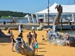 OXON HILL, MD - AUGUST 24: Awakening Sculpture at National Harbor on August 24, 2013 at Oxon Hill, MD USA. A famous 70-foot statue of a giant embedded in the earth created by J. Seward Johnson Jr.