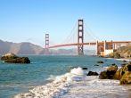 San Francisco Golden Gate Bridge from Baker Beach with pacific Ocean surf and waves.