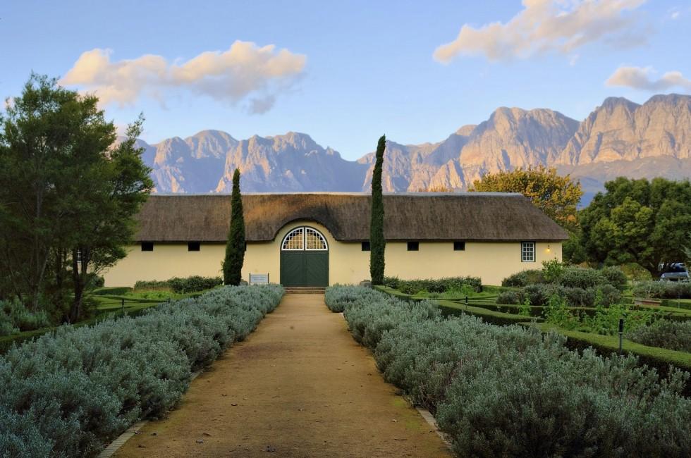 African boer house against misty mountains in sunset light. Shot in Vergelegen wine farm/estate, near Stellenbosch, Western Cape, South Africa