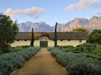 African boer house against misty mountains in sunset light. Shot in Vergelegen wine farm/estate, near Stellenbosch, Western Cape, South Africa