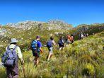 File of hikers walks in mountains. Shot on Pieke, Jonkershoek Nature Reserve, near Stellenbosch, Western Cape, South Africa.