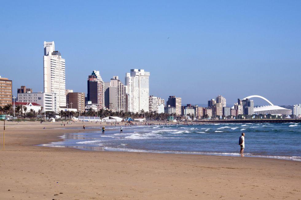 DURBAN, SOUTH AFRICA - DECEMBER 18, 2014: Many unknown people on South Beach against "Golden Mile" city skyline in Durban, South Africa