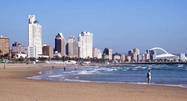 DURBAN, SOUTH AFRICA - DECEMBER 18, 2014: Many unknown people on South Beach against "Golden Mile" city skyline in Durban, South Africa