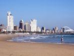 DURBAN, SOUTH AFRICA - DECEMBER 18, 2014: Many unknown people on South Beach against "Golden Mile" city skyline in Durban, South Africa