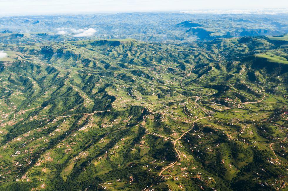 Air Flying Landscape Rural Habitat Air flying birds eye view of rural habitat homes in thousand hills terrain landscape .